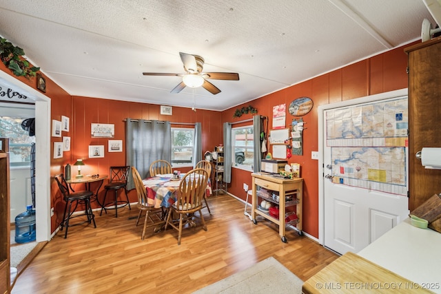 dining space with ceiling fan, light hardwood / wood-style floors, and a textured ceiling