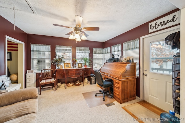 home office featuring ceiling fan, plenty of natural light, carpet floors, and a textured ceiling