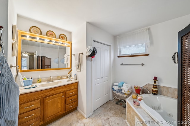 bathroom featuring a relaxing tiled tub, tile patterned floors, and vanity