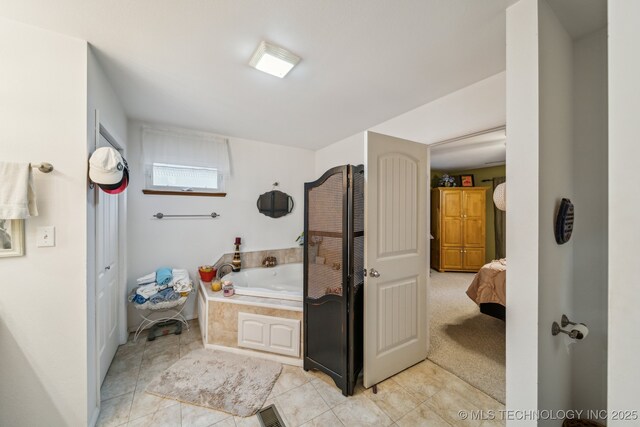 bathroom featuring tile patterned flooring and a relaxing tiled tub