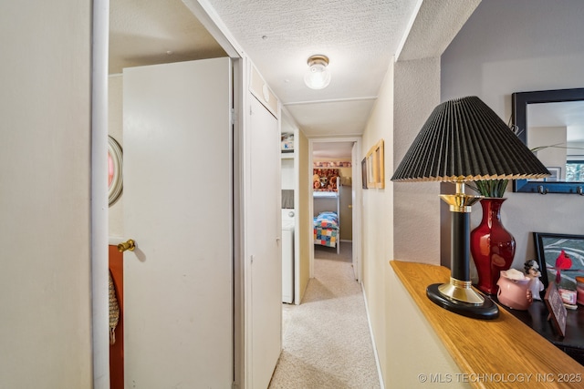 corridor featuring light colored carpet and a textured ceiling