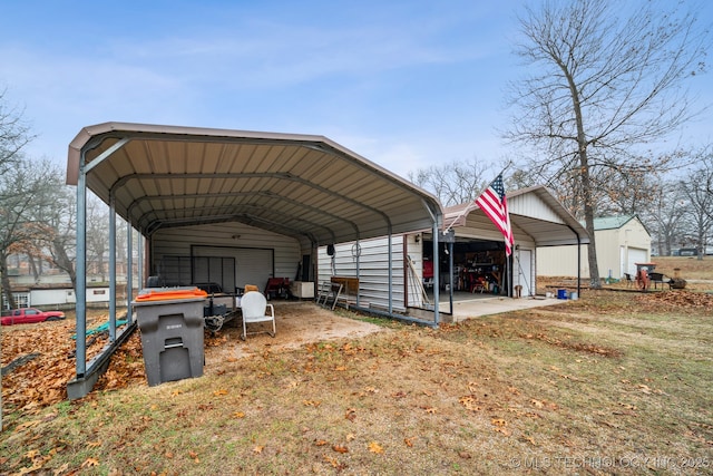 view of outbuilding with a carport, a garage, and a lawn