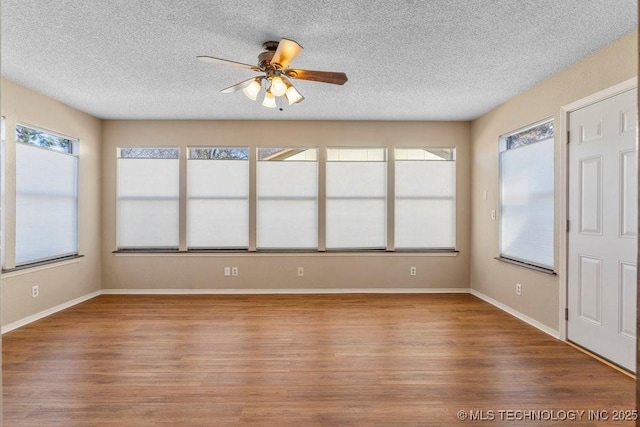 unfurnished sunroom with ceiling fan