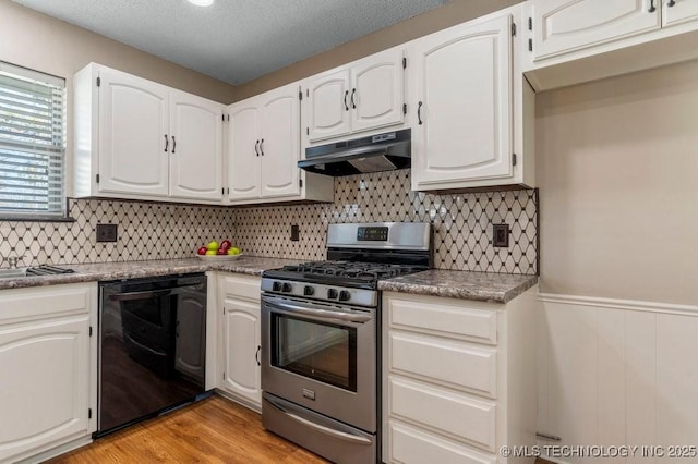 kitchen featuring black dishwasher, stainless steel gas range, light hardwood / wood-style floors, and white cabinets