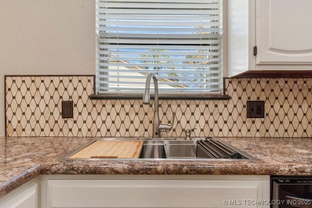 details featuring backsplash, dishwasher, sink, and white cabinets