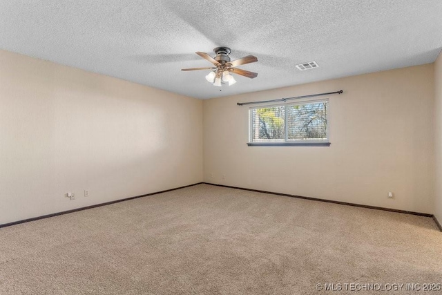 spare room with ceiling fan, light carpet, and a textured ceiling