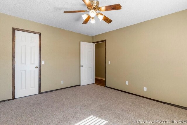 carpeted spare room featuring ceiling fan and a textured ceiling