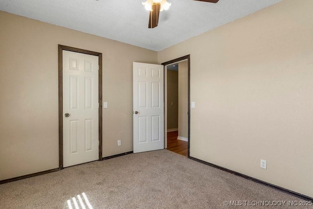 unfurnished bedroom featuring ceiling fan, carpet floors, and a textured ceiling