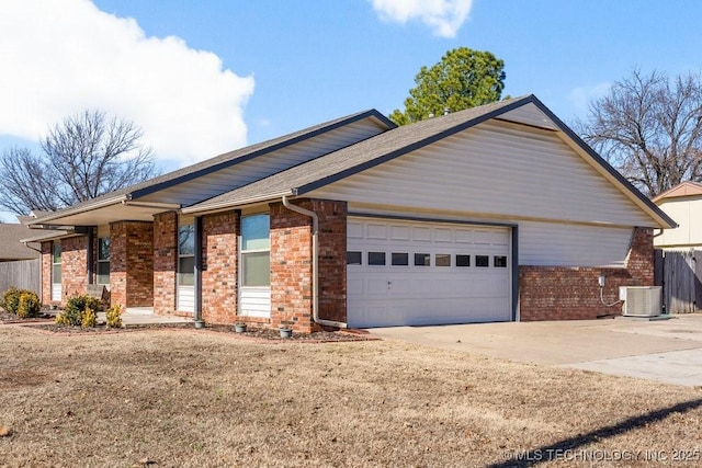 ranch-style house featuring a garage, a front yard, and central air condition unit