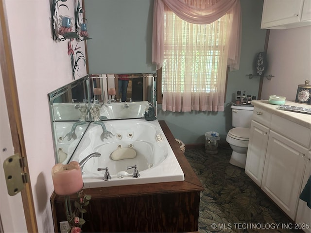 bathroom with vanity, a tub, and toilet