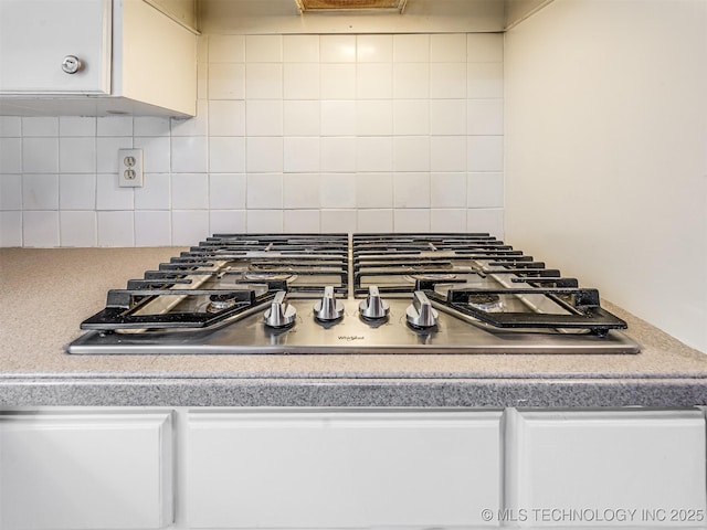 room details with backsplash and stainless steel gas stovetop