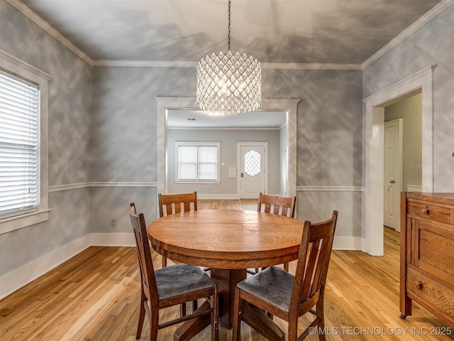 dining area featuring an inviting chandelier, crown molding, and light hardwood / wood-style floors