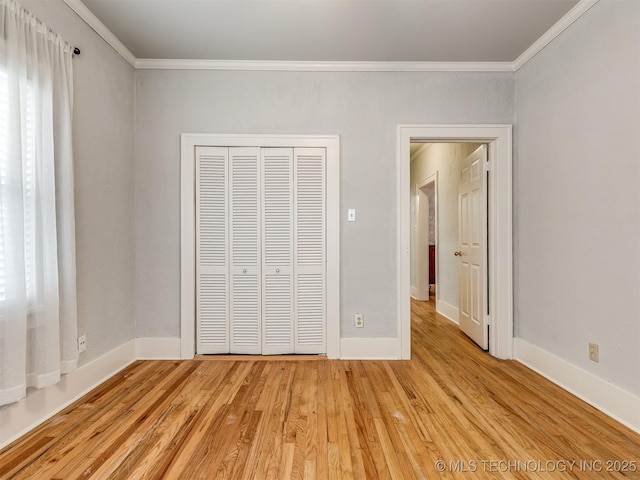 unfurnished bedroom with ornamental molding, a closet, and light hardwood / wood-style flooring