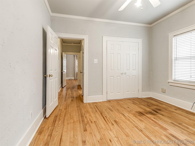 unfurnished bedroom featuring crown molding, a closet, ceiling fan, and light wood-type flooring