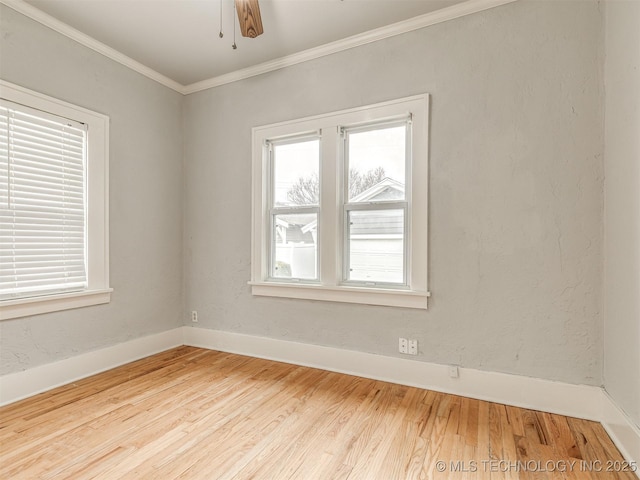 empty room featuring crown molding, plenty of natural light, ceiling fan, and hardwood / wood-style flooring