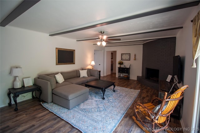 living room with dark wood-type flooring, a fireplace, beam ceiling, and ceiling fan