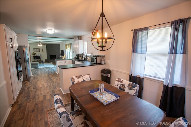 dining space featuring sink, a chandelier, and dark hardwood / wood-style floors