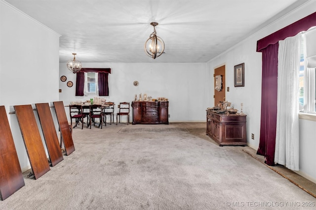 dining room featuring light colored carpet, ornamental molding, and a chandelier