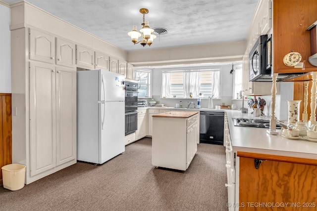 kitchen with an inviting chandelier, black appliances, white cabinets, and a kitchen island