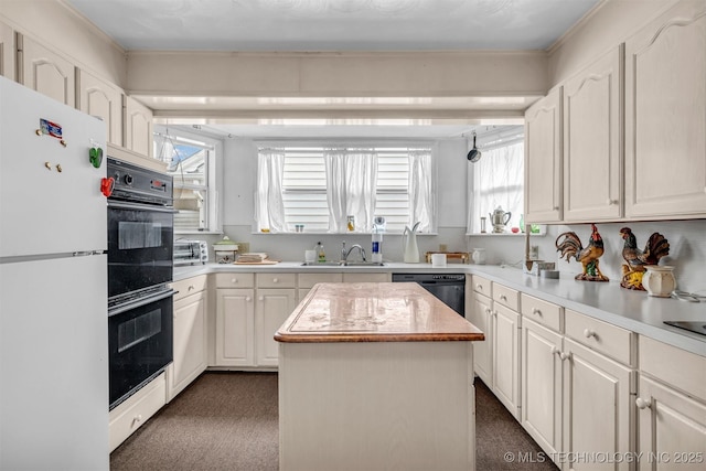 kitchen featuring white cabinetry, sink, black appliances, and a kitchen island