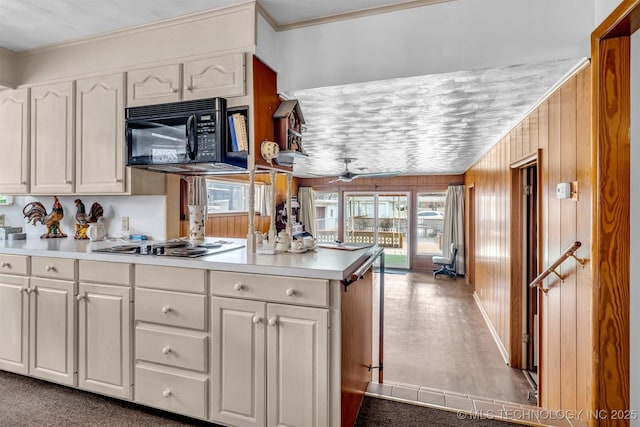 kitchen featuring ceiling fan, wooden walls, ornamental molding, white cabinets, and kitchen peninsula