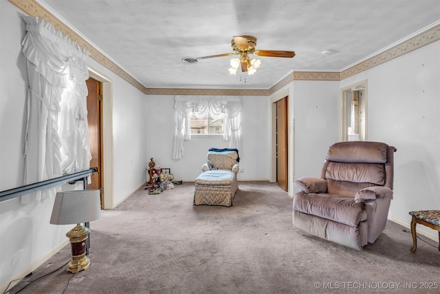 sitting room with ornamental molding, carpet flooring, and ceiling fan