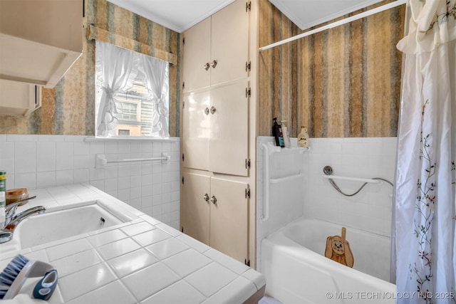 bathroom featuring shower / bathtub combination with curtain, sink, and tile walls