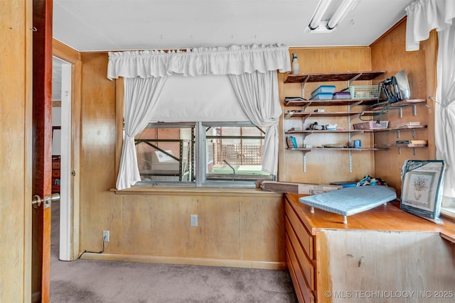 bedroom with light carpet and wooden walls