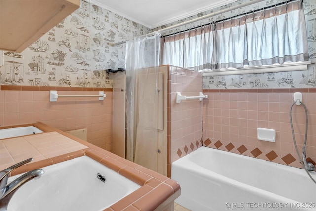 bathroom featuring shower / tub combo with curtain, sink, and tile walls