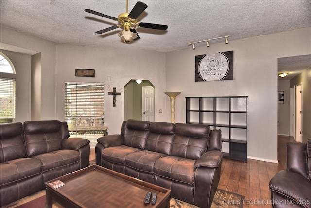 living room with a healthy amount of sunlight, dark hardwood / wood-style floors, and a textured ceiling