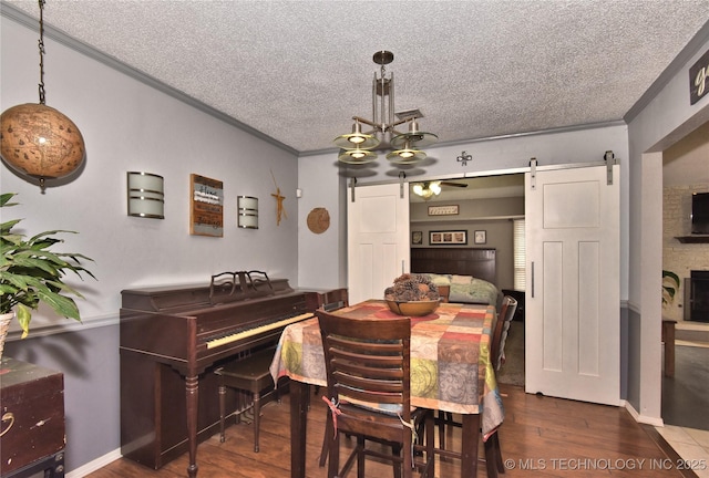 dining room with hardwood / wood-style flooring, crown molding, a barn door, and a textured ceiling