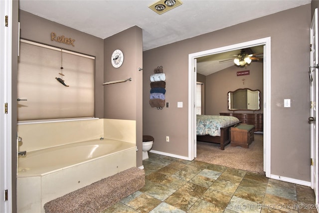 bathroom with a tub, lofted ceiling, ceiling fan, and toilet