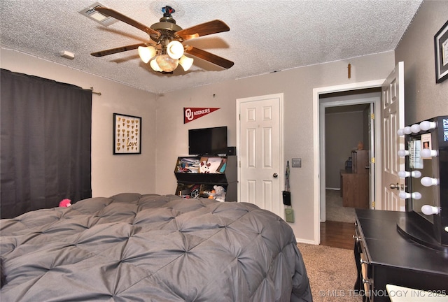 carpeted bedroom with ceiling fan and a textured ceiling