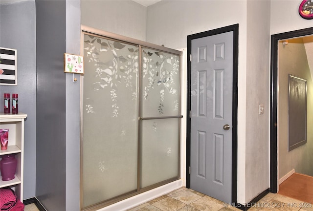 bathroom with tile patterned flooring and a shower with door