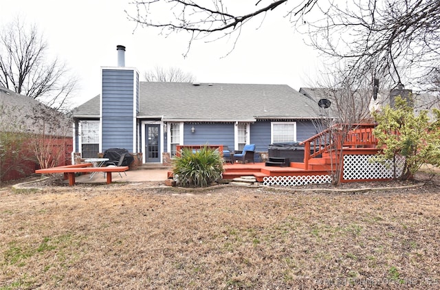 rear view of property featuring a yard, a hot tub, a deck, and a patio