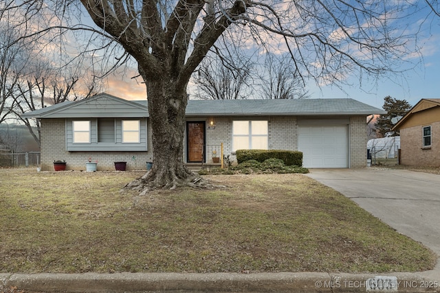 single story home featuring a garage and a lawn