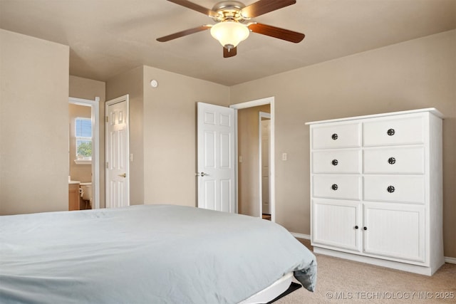 carpeted bedroom featuring ceiling fan and ensuite bath