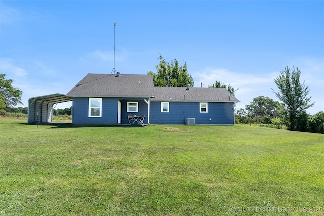 rear view of property featuring central AC, a carport, and a yard