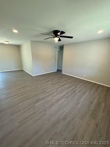 spare room featuring dark hardwood / wood-style flooring and ceiling fan