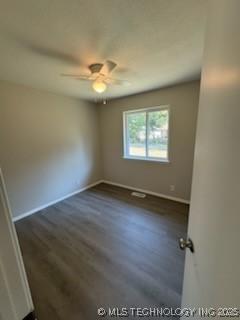 unfurnished room with dark wood-type flooring and ceiling fan