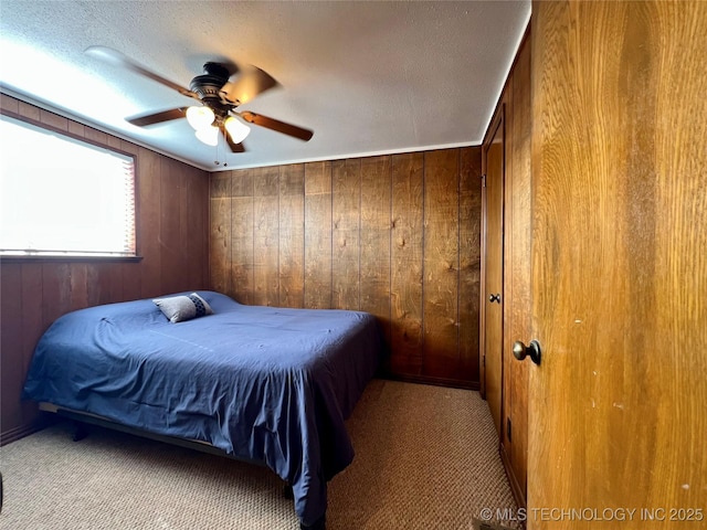 4 Canadian Dr, Burneyville, OK 73430 - bedroom with wood walls, a textured ceiling, ceiling fan, and carpet floors