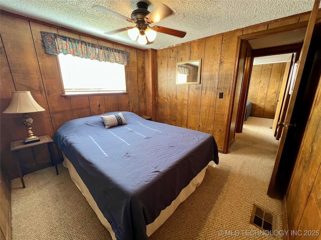 4 Canadian Dr, Burneyville, OK 73430 - bedroom featuring wood walls, light carpet, a textured ceiling, and a ceiling fan