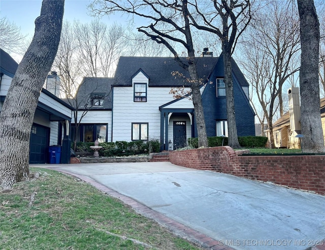 view of front of home featuring driveway and a chimney