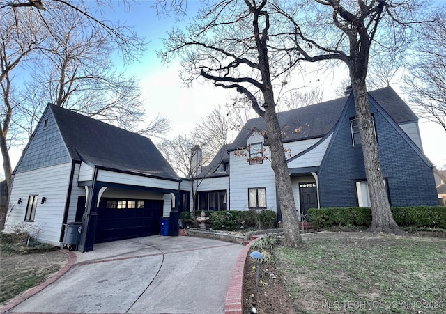 view of front facade with concrete driveway, an attached garage, and a shingled roof