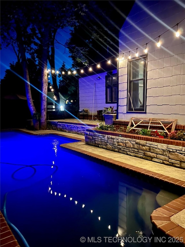 8918 S Lakewood Ave, Tulsa, OK 74137 - pool at night featuring an outdoor pool and a patio