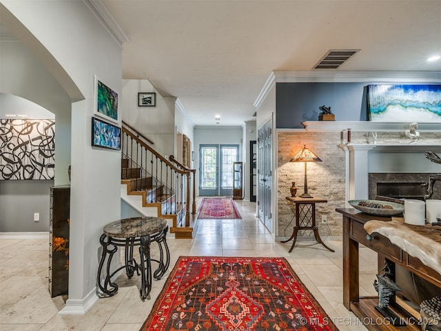 8918 S Lakewood Ave, Tulsa, OK 74137 - entryway featuring crown molding, stairs, arched walkways, a fireplace, and tile patterned floors