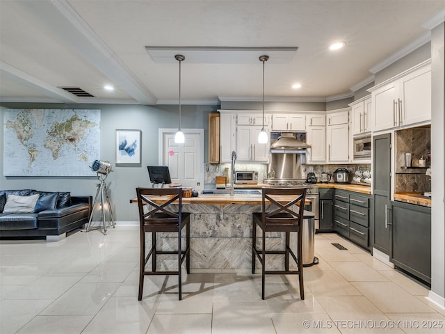8918 S Lakewood Ave, Tulsa, OK 74137 - kitchen with appliances with stainless steel finishes, tasteful backsplash, white cabinetry, under cabinet range hood, and recessed lighting