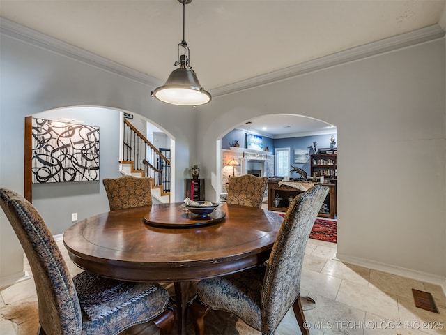 8918 S Lakewood Ave, Tulsa, OK 74137 - dining area featuring ornamental molding, arched walkways, a fireplace, and stairway