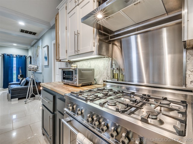 8918 S Lakewood Ave, Tulsa, OK 74137 - kitchen featuring high end stove, white cabinetry, butcher block counters, decorative backsplash, and light tile patterned flooring