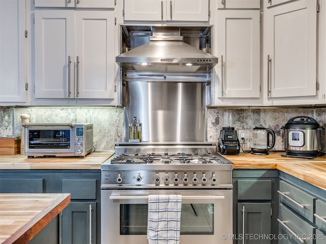 8918 S Lakewood Ave, Tulsa, OK 74137 - kitchen with high end range, butcher block counters, backsplash, and wall chimney exhaust hood